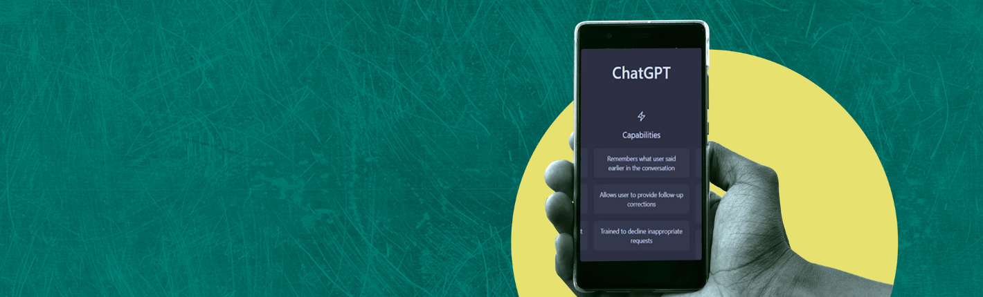 En hånd holder en smartphone med ChatGPT appen åben, mod en grøn baggrund med en gul halvcirkel.